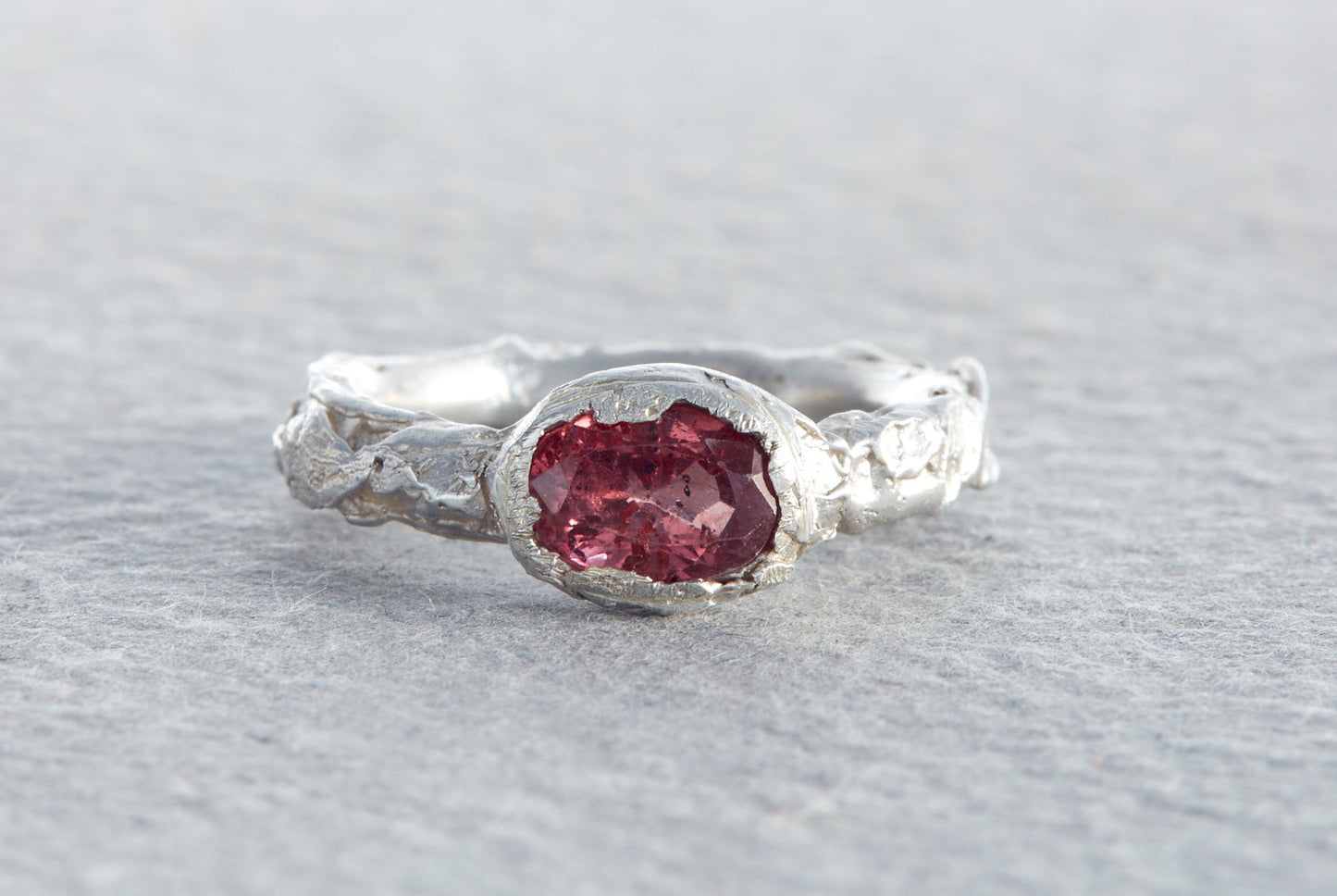 Chunky sculptural sterling silver ring with raspberry sapphire and molten textured organic surface made in North Devon studio