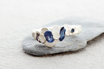 Coastal inspired silver ring with organic surface texture shells and ethically sourced sapphires