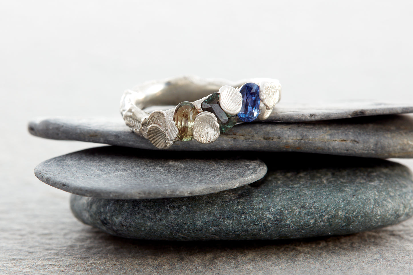 Sculptural silver Shellscape ring with organic ocean-inspired texture and multicolour sapphires in blue, teal and green tones. Handmade in Devon