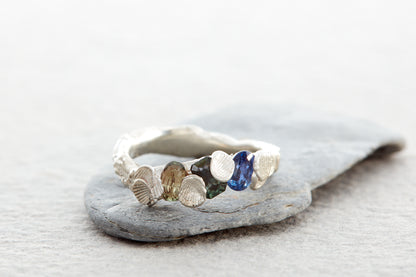 Sculptural silver Shellscape ring with organic coastal texture inspired by Devon shores and multicolour blue, teal and green sapphires.