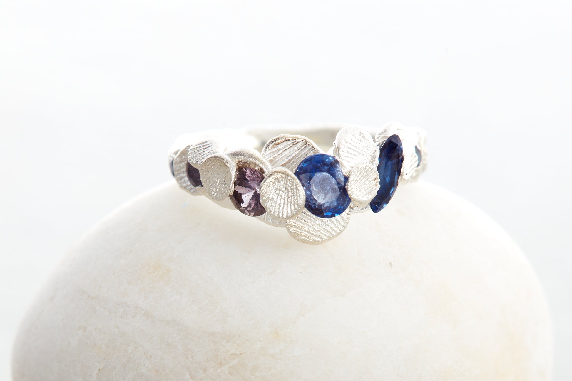 Handcrafted Shellscape Tidepool ring in recycled silver with blue sapphires and reddish brown sapphire inspired by North Devon coastline