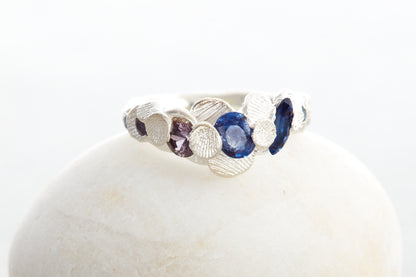 Handcrafted Shellscape Tidepool ring in recycled silver with blue sapphires and reddish brown sapphire inspired by North Devon coastline