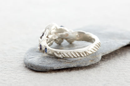 Coastal inspired silver ring with organic surface texture shells and ethically sourced sapphires