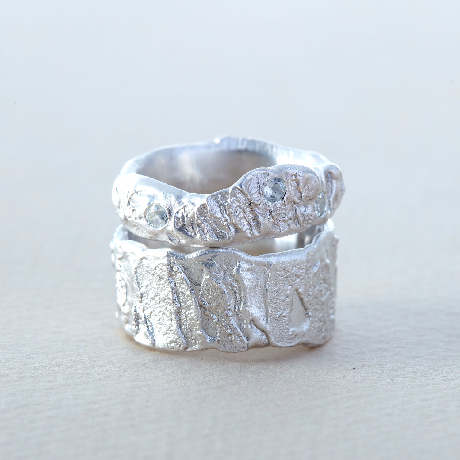 Two chunky contemporary silver rings exploring raw rock textures and set with natural moonstones, Ania Wawrzkowicz Fine Jewellery